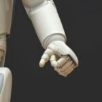Close-up of an arduino-powered robotic arm with articulated fingers in a relaxed position.
