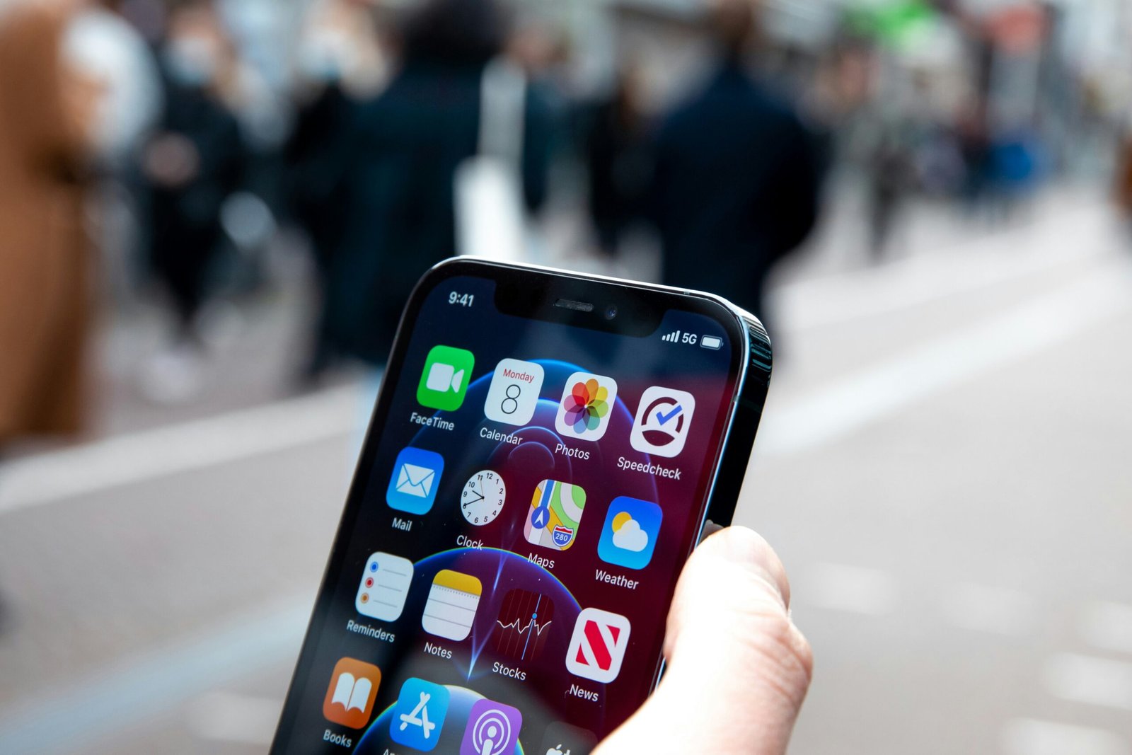 erson holding a smartphone with visible app icons, showcasing 5G cellular communication network connectivity in a public urban setting.